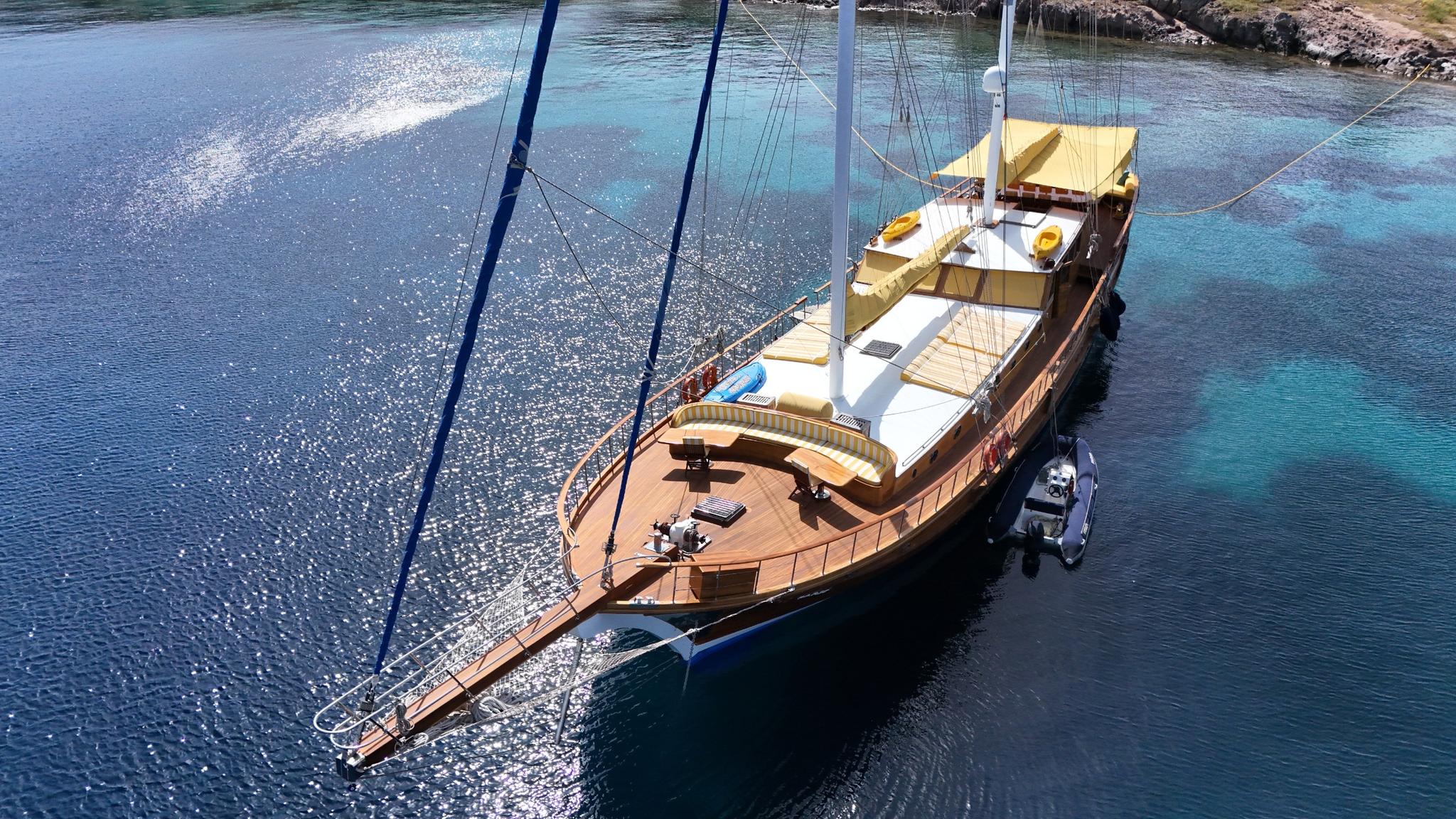 aerial view of traditional wooden gulet yacht anchored in crystal clear turquoise waters