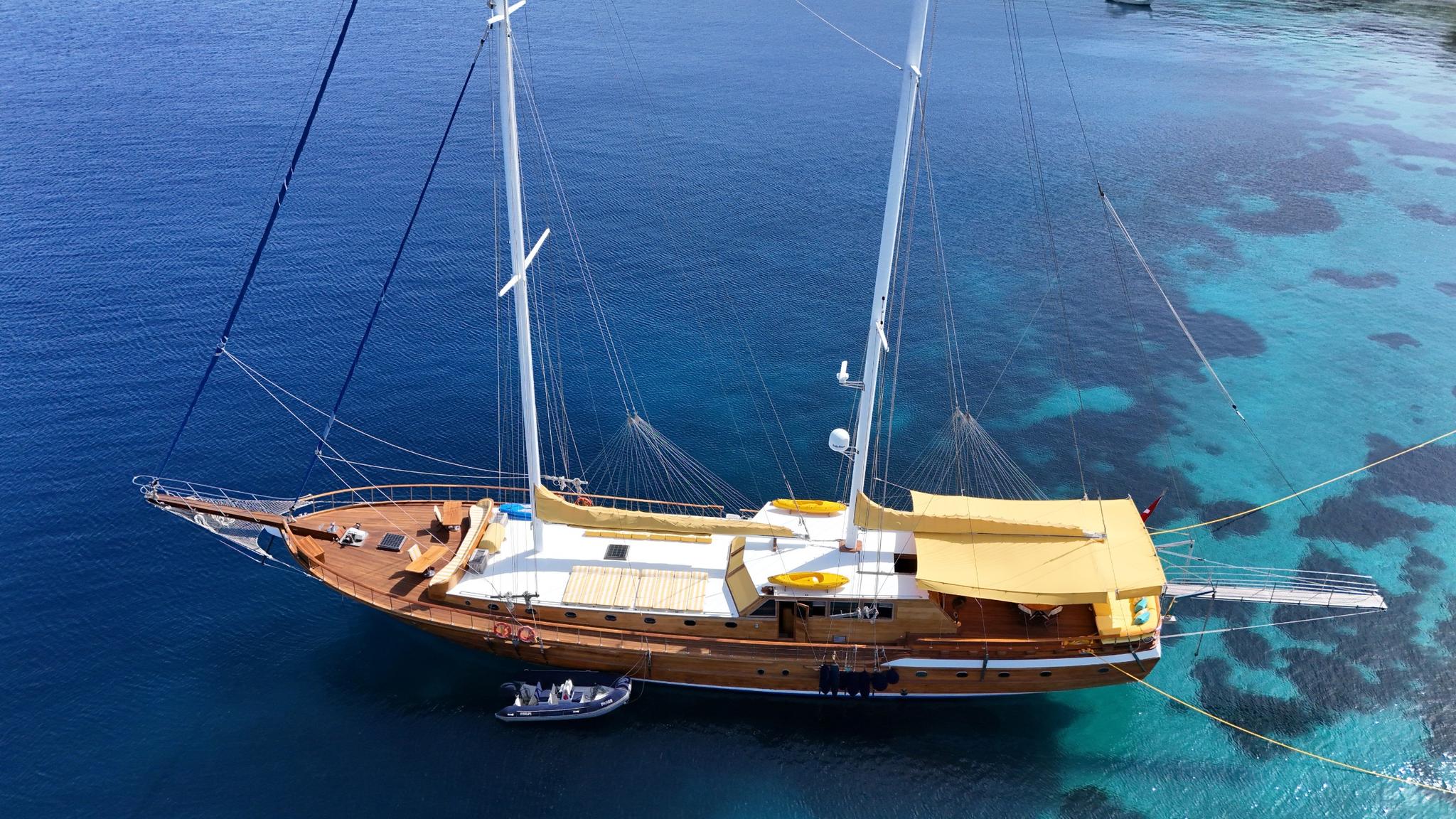 aerial view of traditional wooden gulet yacht anchored in crystal clear turquoise Mediterranean waters