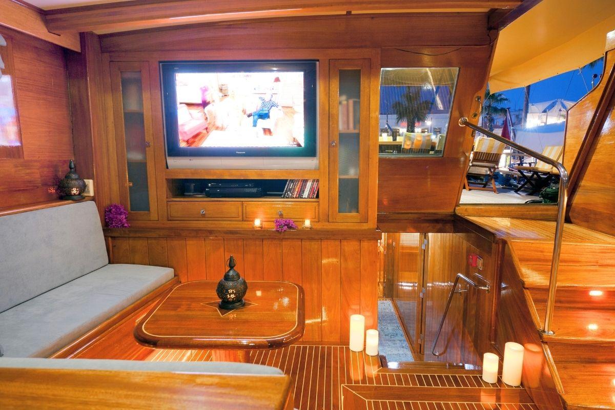 luxury yacht cinema room featuring built-in entertainment center with large flatscreen TV and comfortable seating