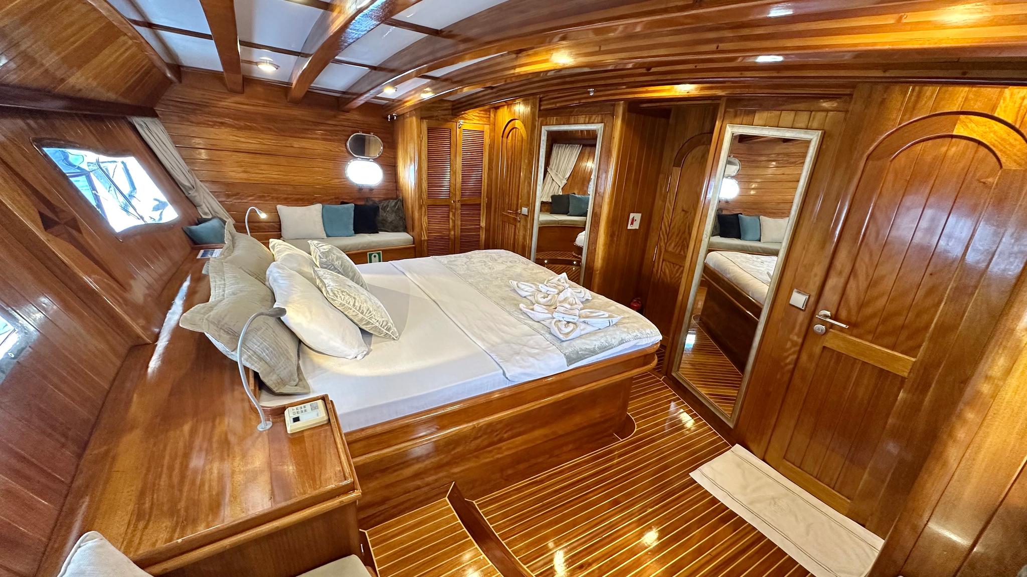 luxurious master cabin featuring double bed with white linens and built-in seating area