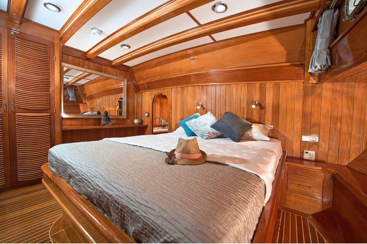 yacht guest cabin featuring double bed with decorative pillows and full wooden interior