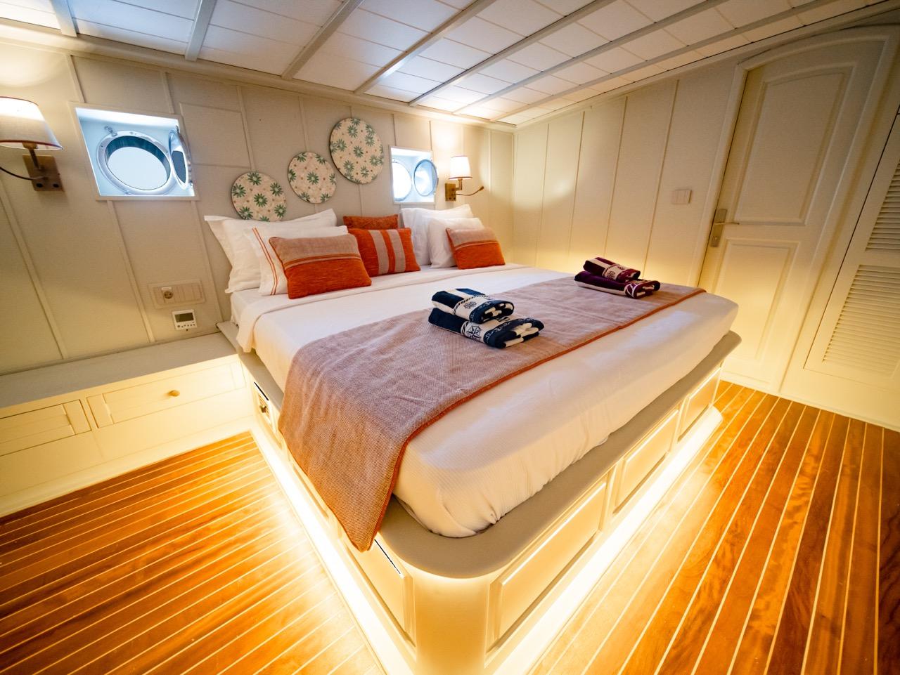 guest cabin featuring double bed with orange accent pillows and decorative plates on wall