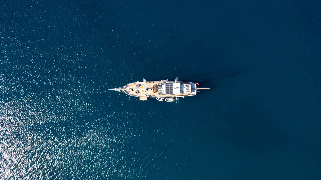 Aerial view of white luxury yacht anchored in deep blue Mediterranean waters