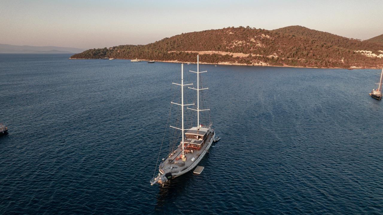 aerial view of traditional sailing yacht with white masts anchored in Mediterranean bay