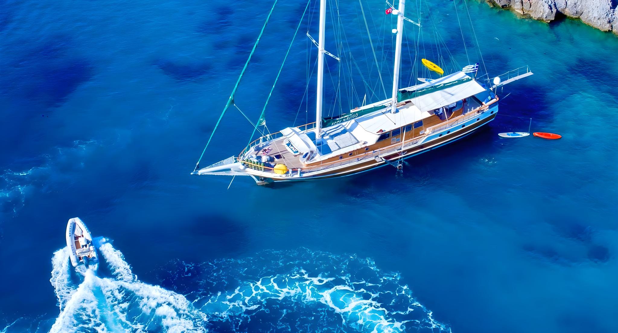 aerial view of traditional wooden gulet yacht at anchor in crystal clear turquoise waters