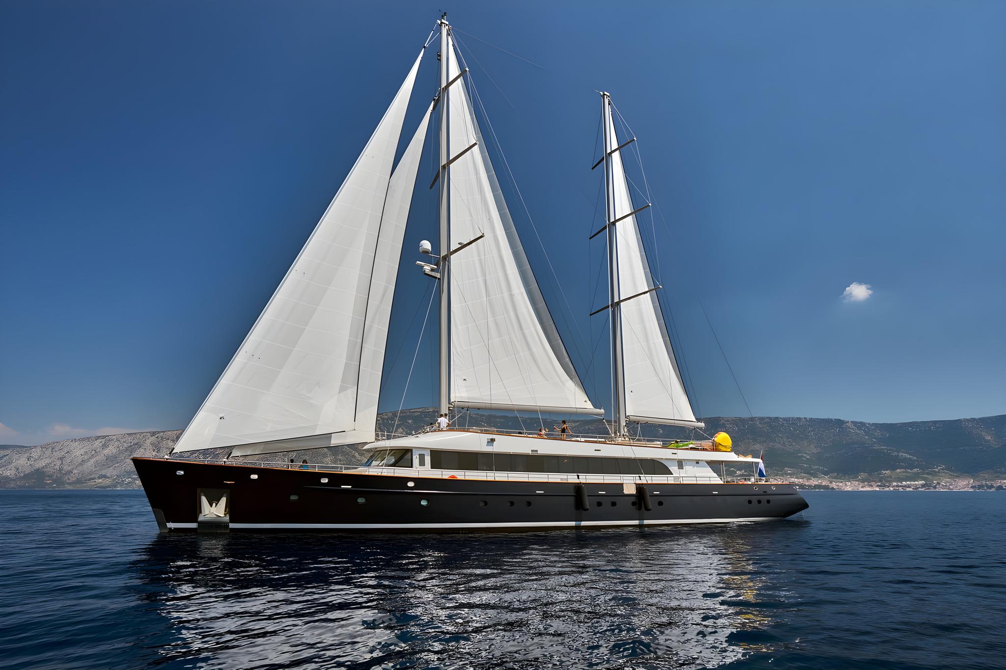 luxury sailing yacht with white sails cruising Mediterranean waters near coastline