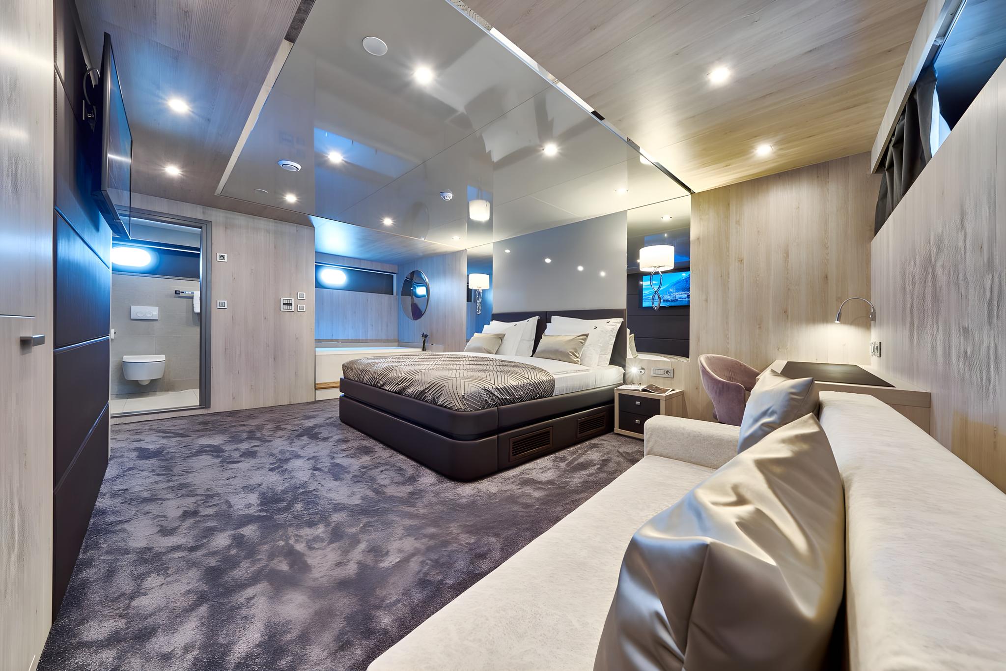 Spacious yacht master cabin with king bed, leather seating, and en-suite bathroom