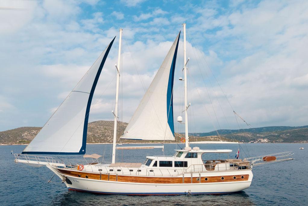 Traditional gulet sailing yacht with white sails anchored in Mediterranean waters