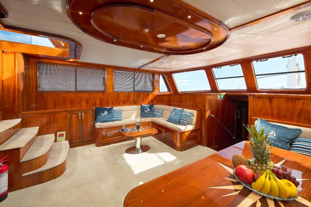 Elegant yacht salon interior featuring rich wood paneling and cream seating