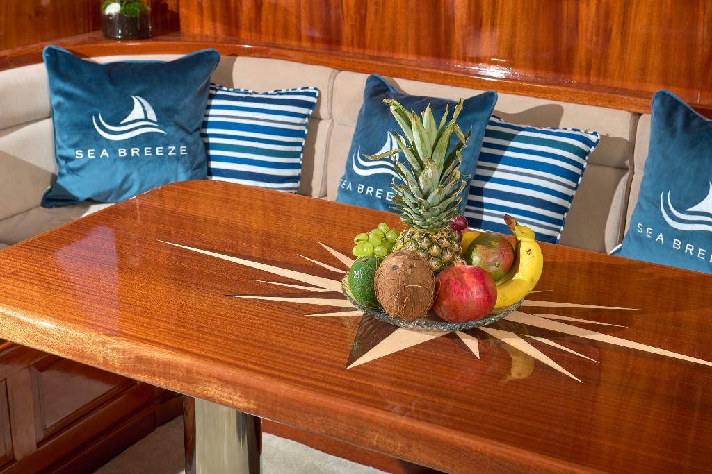 yacht salon interior with Sea Breeze branded pillows and fresh fruit display