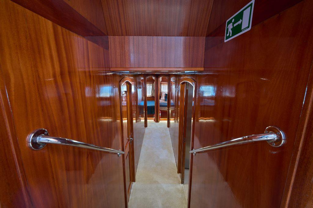 luxury yacht interior staircase with polished wood paneling and chrome handrails