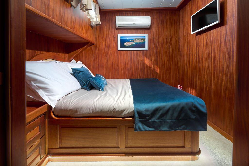 luxury yacht guest cabin with teak paneling single bed white linens