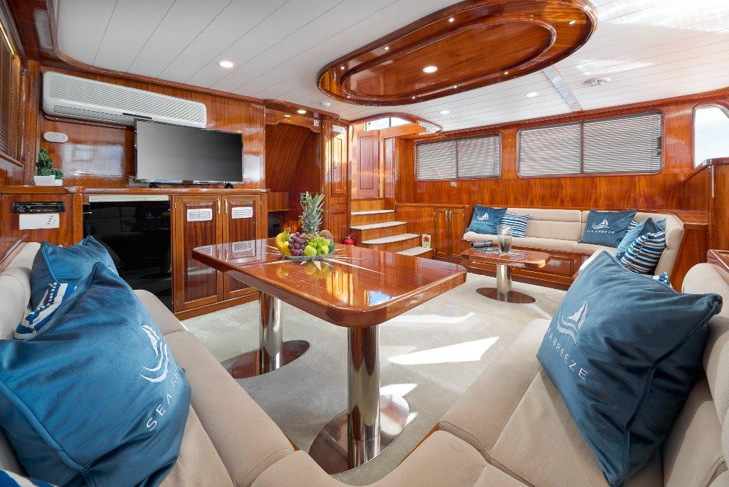 luxury yacht main salon with mahogany paneling cream leather seating dining table