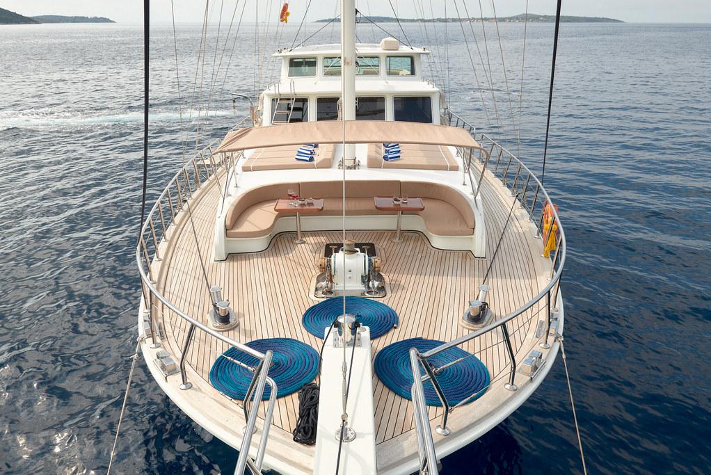 luxury sailing yacht foredeck with teak decking curved seating and blue ropes