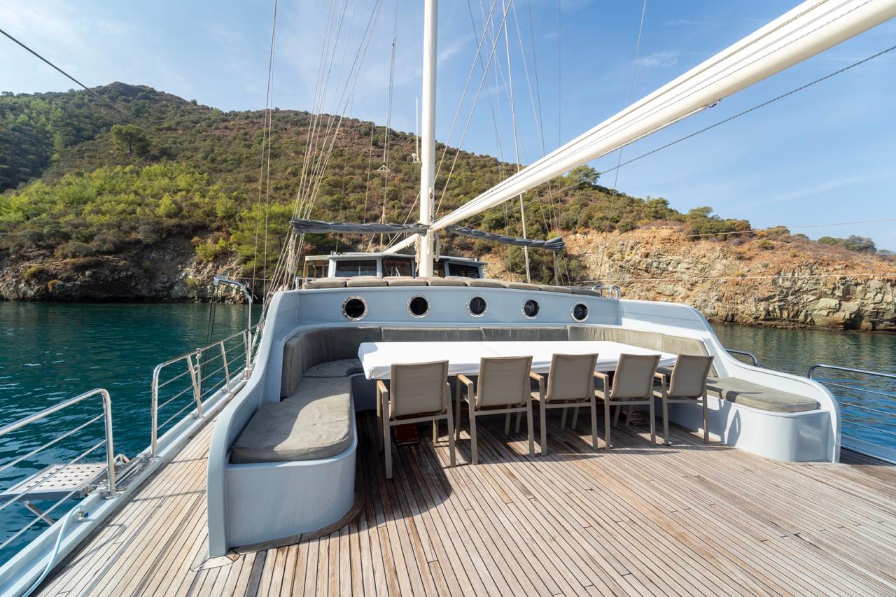luxury yacht aft deck with curved banquette seating and outdoor dining table