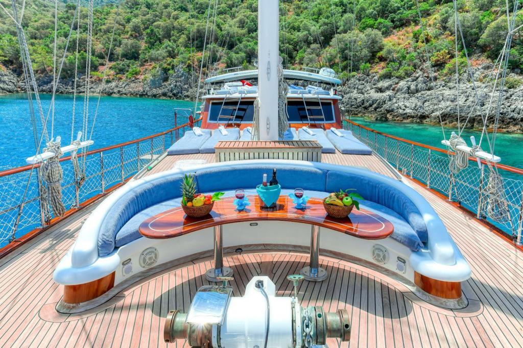 forward deck jacuzzi with blue cushioned seating and dining table setup