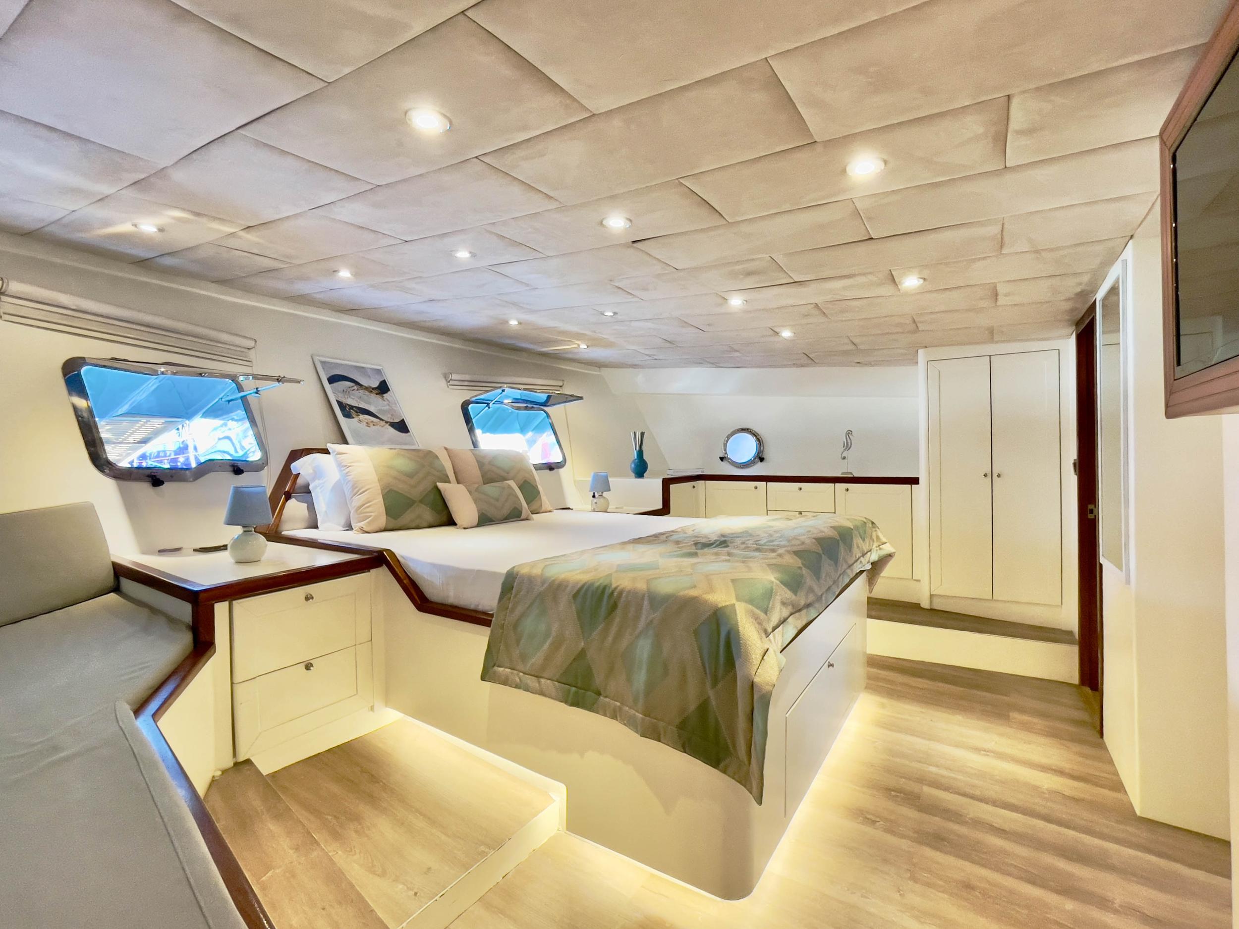 Master cabin with king-size bed, LED under-bed lighting, built-in wardrobes and oval portholes