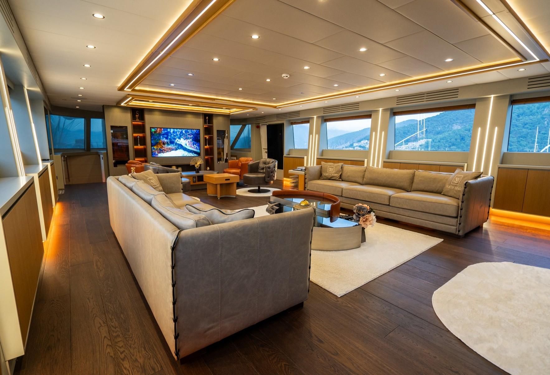 luxury yacht cinema room with wall-mounted TV screen and comfortable gray seating