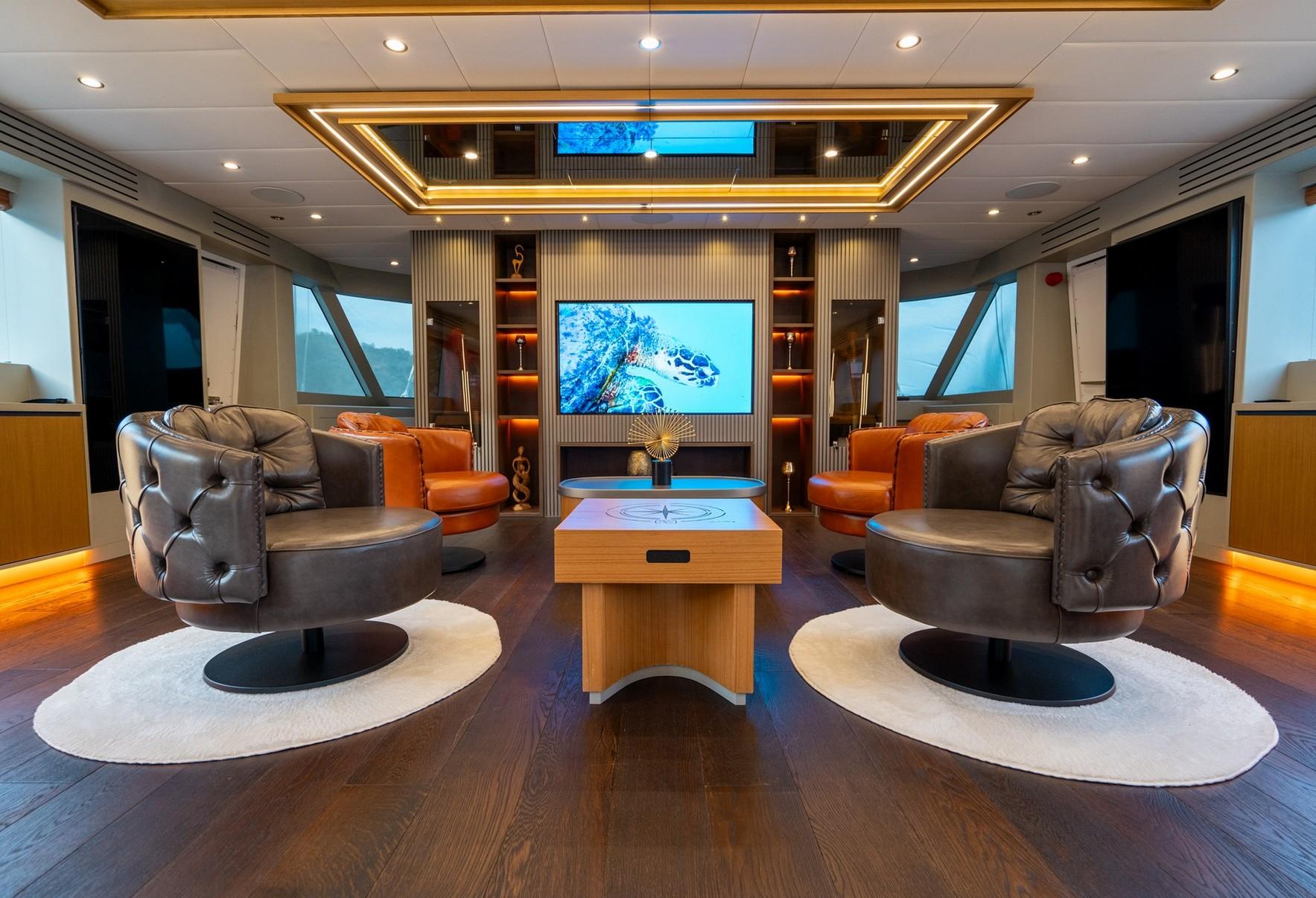 luxury yacht cinema room with wall-mounted screen displaying underwater sea turtle scene