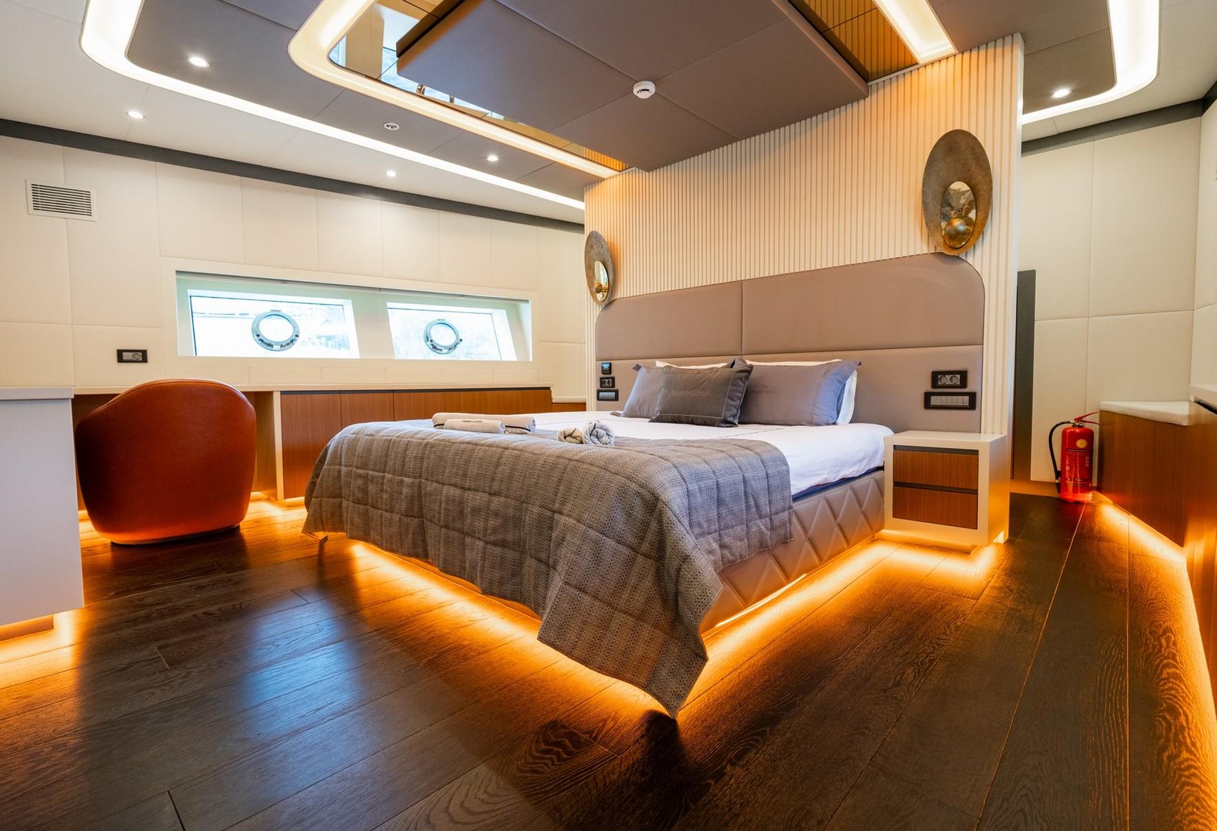 yacht master cabin with king bed, LED floor lighting and oval portholes