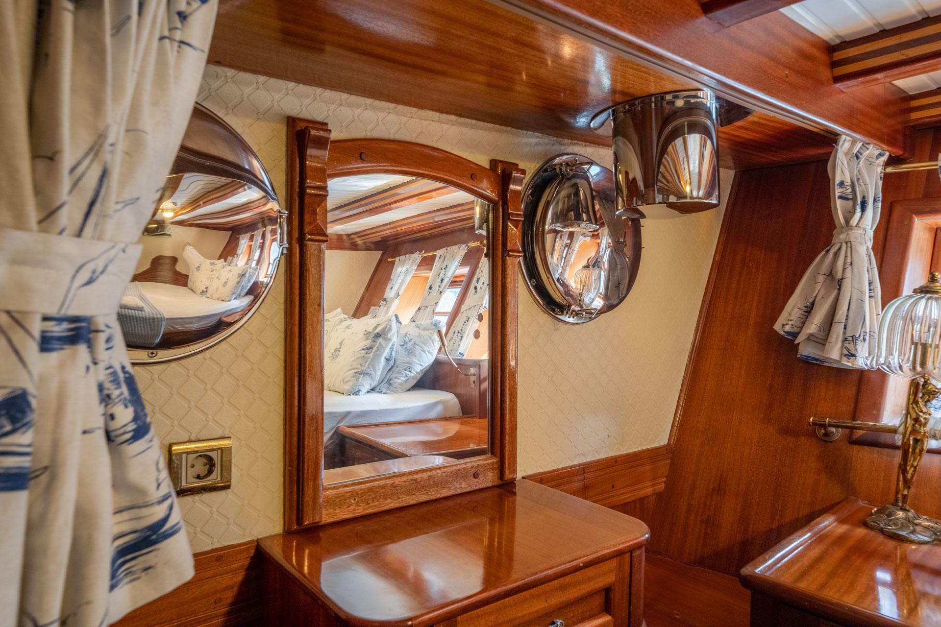 yacht crew accommodation showing tiered bunk beds with white linens and round portholes