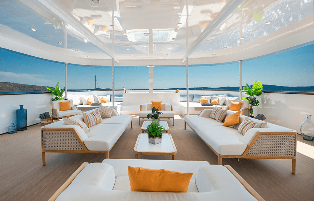 luxury yacht covered aft deck lounge white seating orange pillows