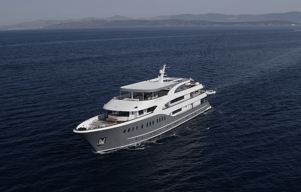 Large white luxury motor yacht cruising through blue Mediterranean waters