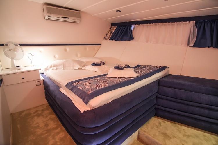 yacht guest cabin featuring double bed with decorative runner and built-in seating