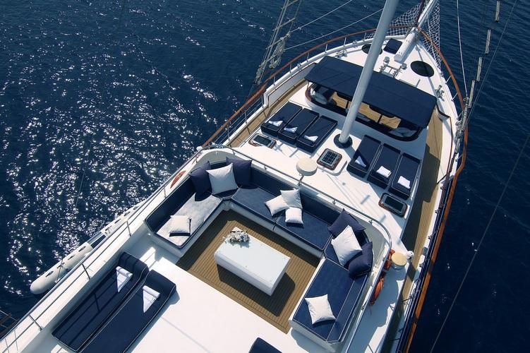 luxury yacht aerial view showing bow seating area with white cushions and upper deck loungers