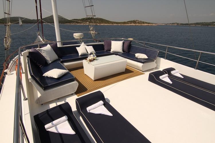 gulet aft deck with navy blue cushioned seating area and white coffee table