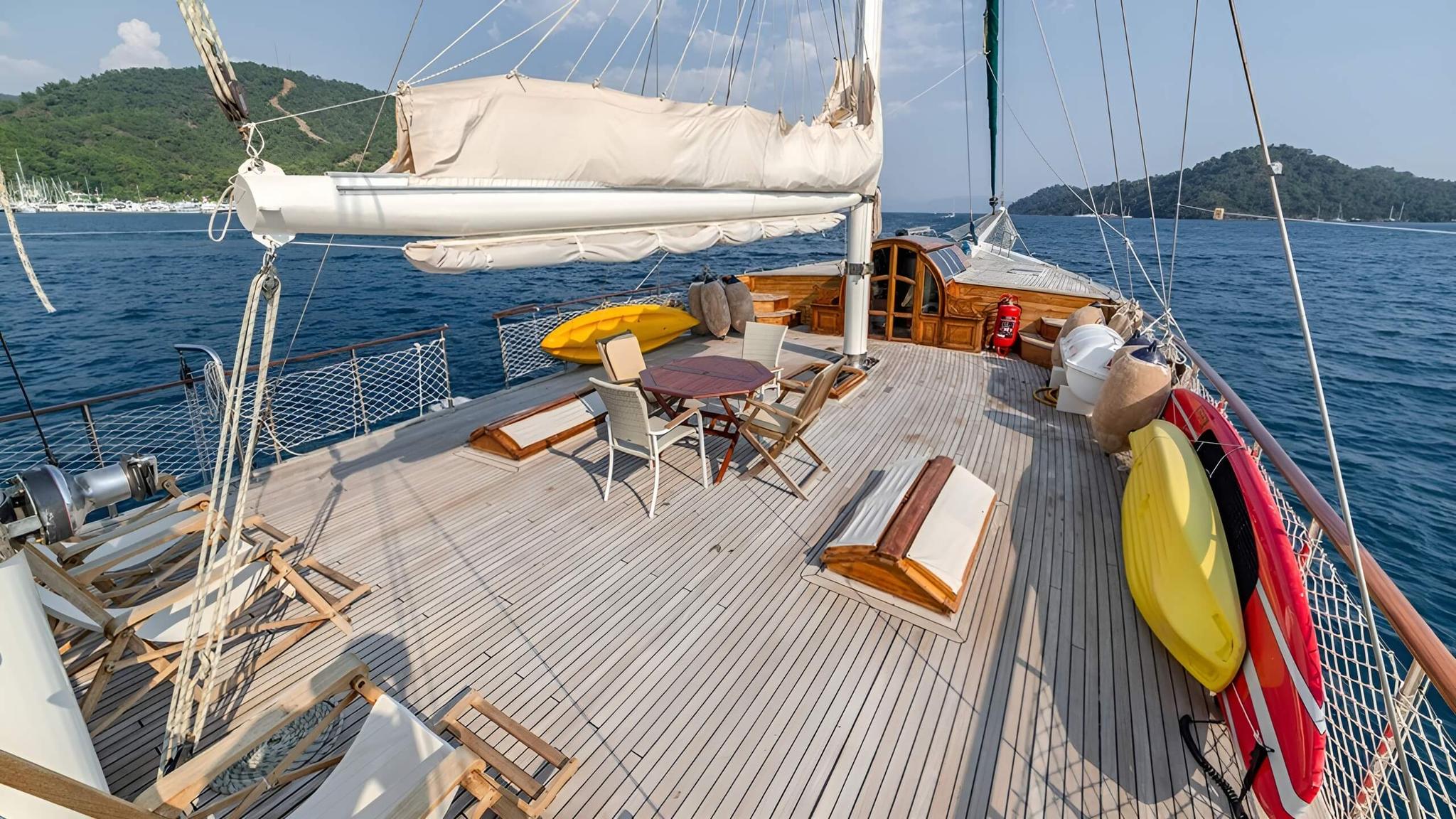 gulet deck with yellow and red kayaks stored on starboard side