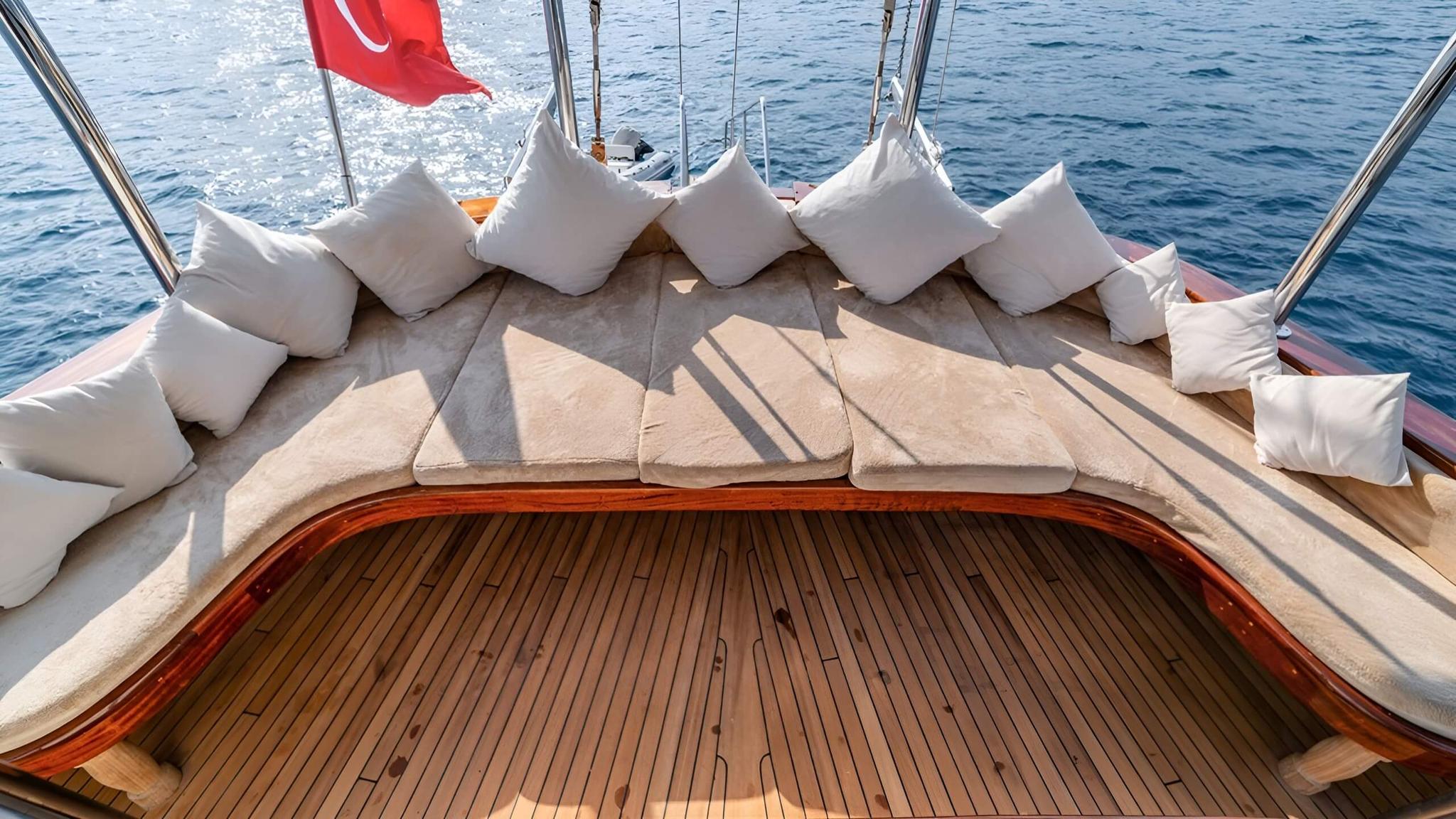 Curved bow seating area with white cushions and beige upholstery on luxury yacht