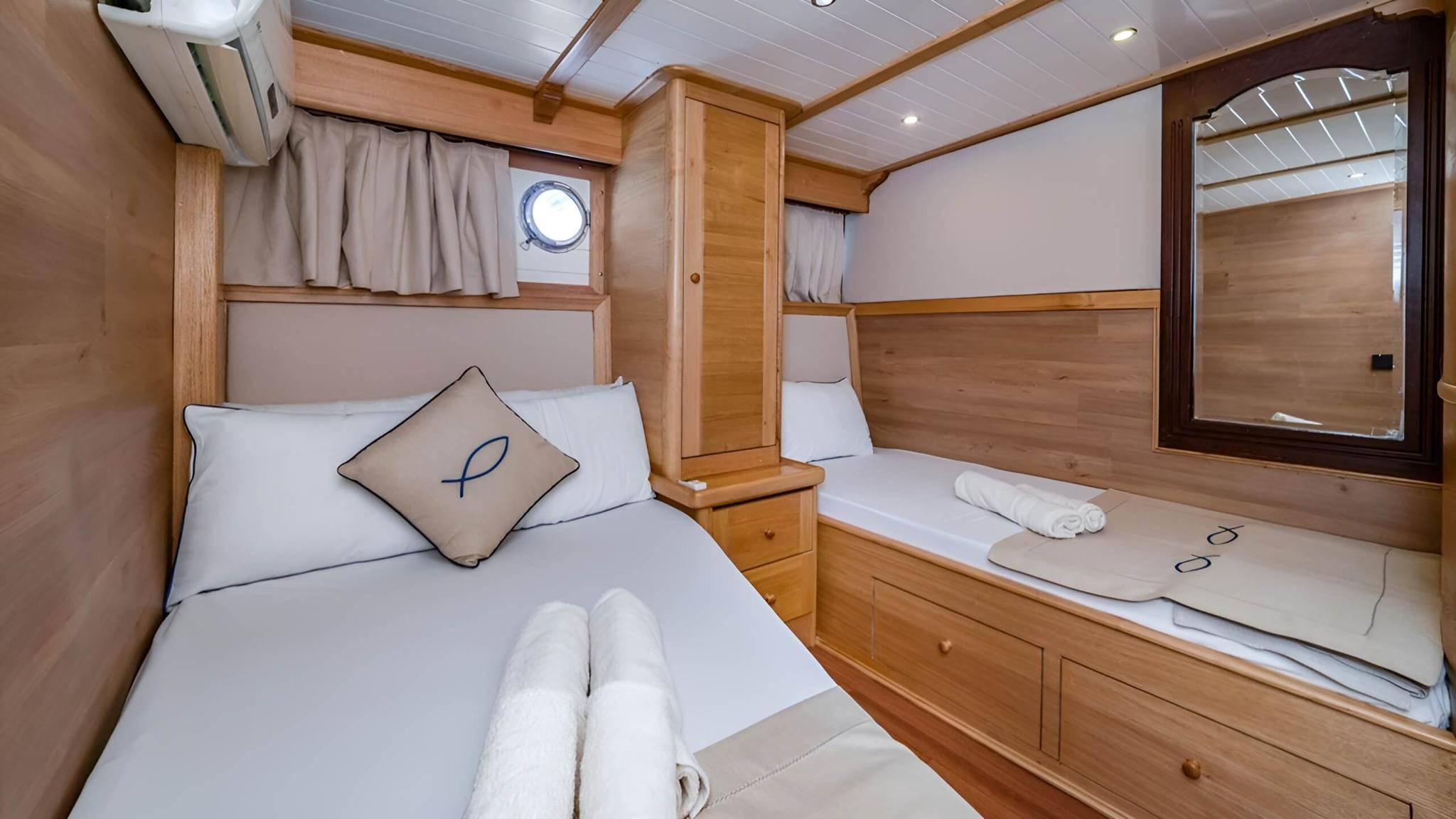 yacht twin cabin featuring single bed and upper bunk with natural wood finishes