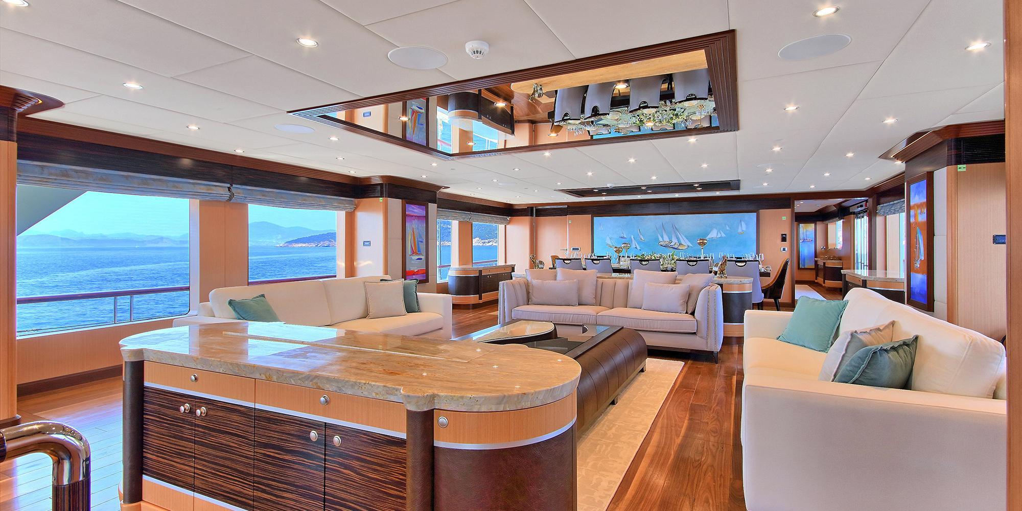 yacht main salon interior with white sofas, marble bar counter and panoramic windows