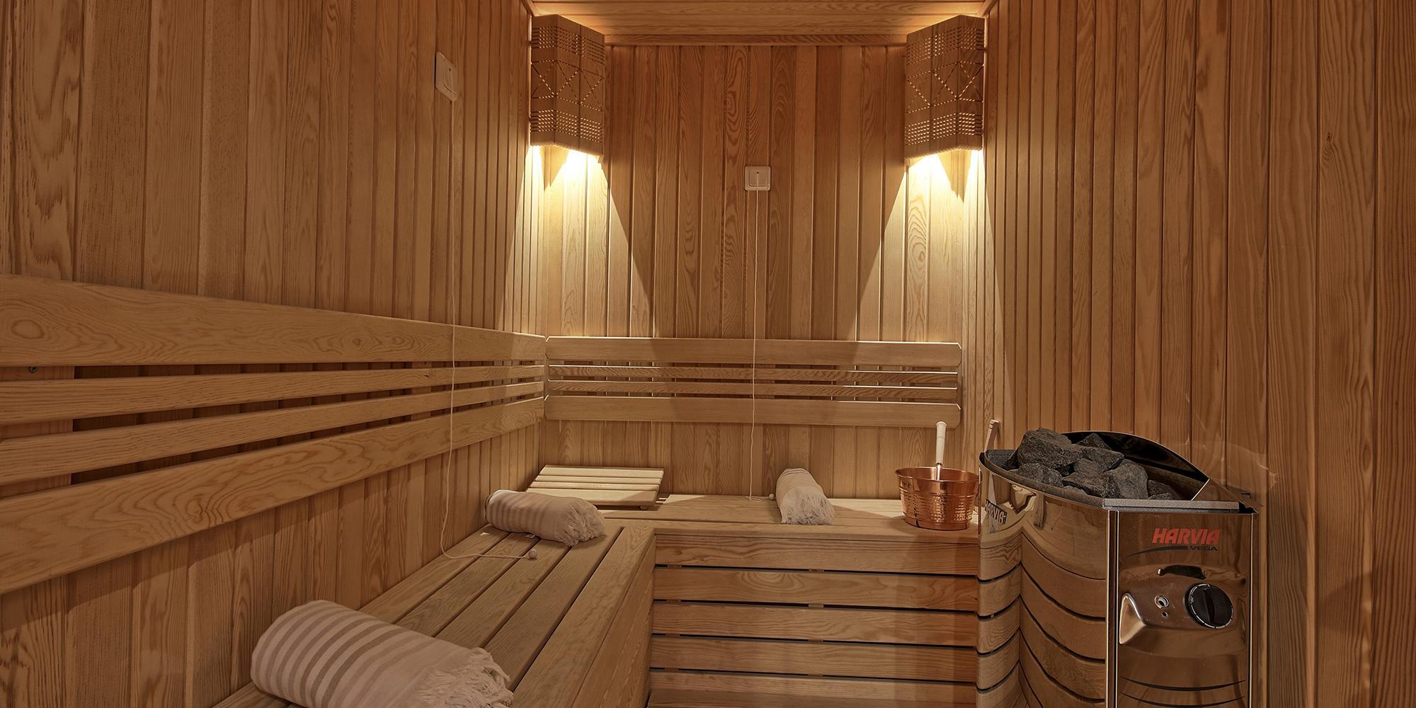 onboard sauna with wooden benches, electric heater with stones, and ambient lighting