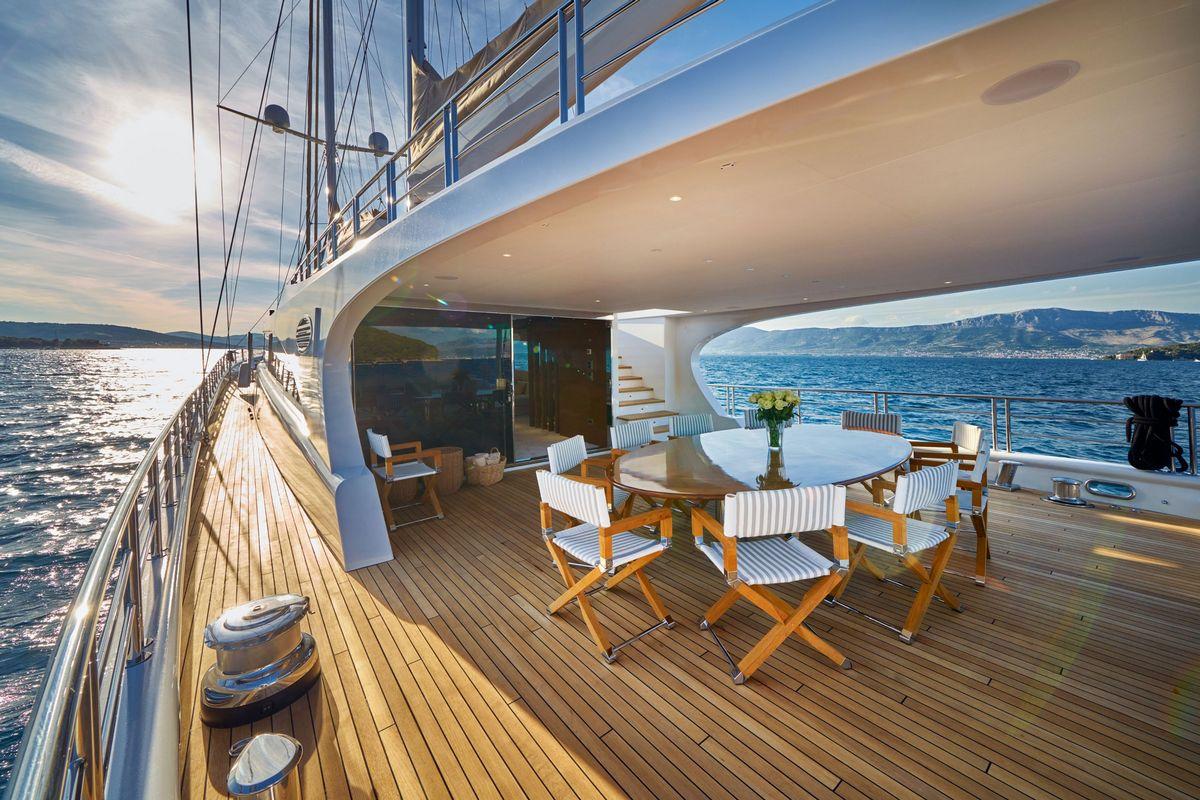 luxury sailing yacht aft deck with outdoor dining table and director chairs