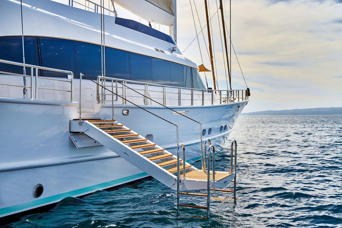 luxury yacht swimming platform with teak decking and stairs in blue water