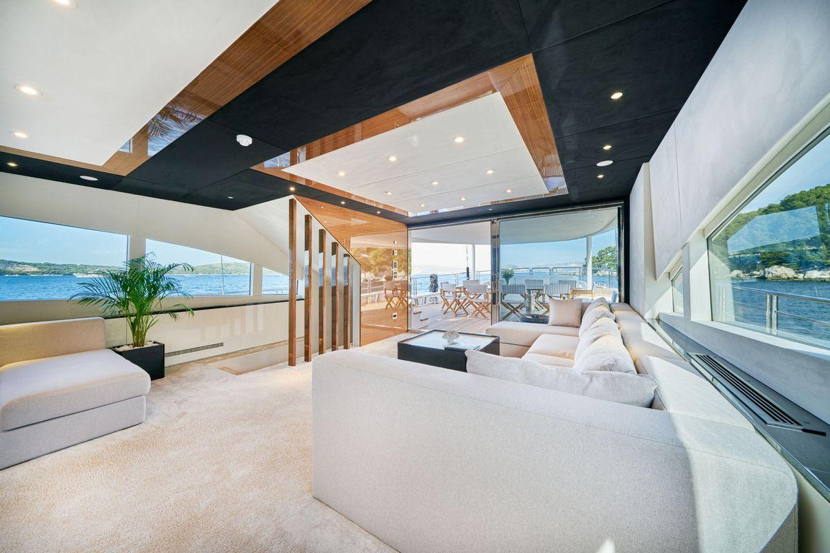luxury yacht main salon with sectional seating and panoramic ocean views