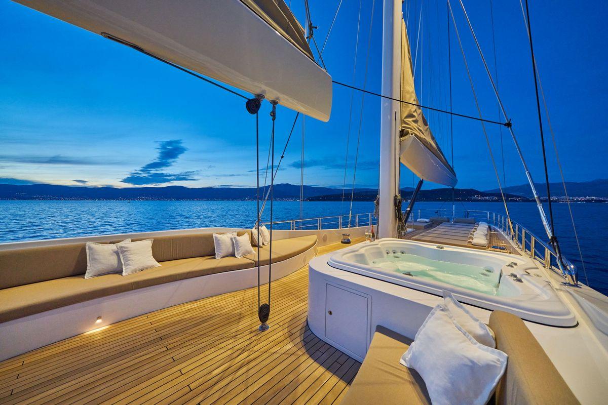 luxury yacht deck jacuzzi hot tub seating area twilight mountain view