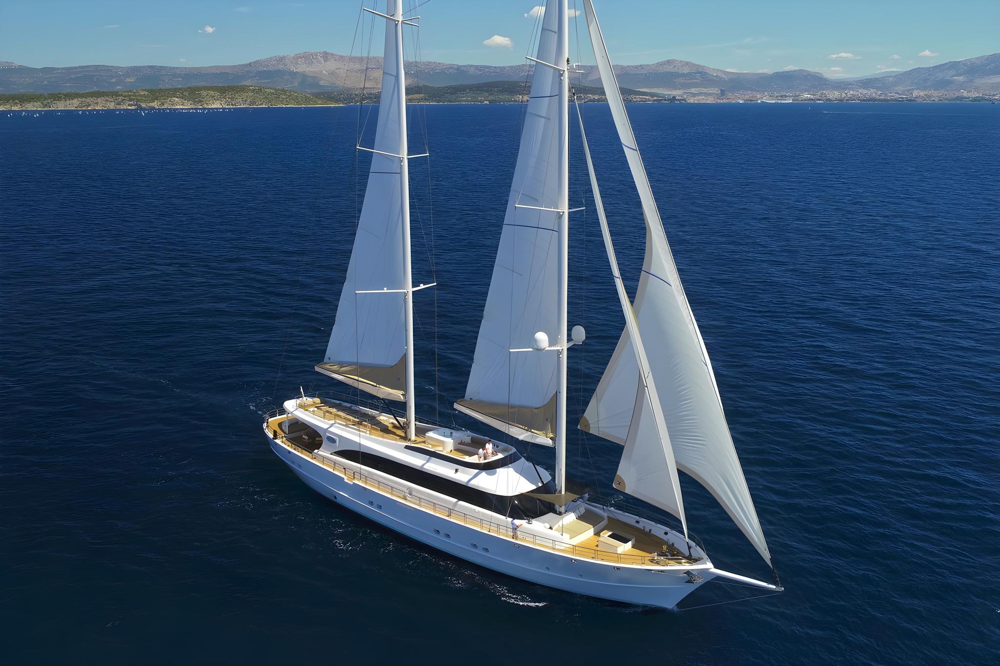aerial view luxury sailing yacht white hull navy stripe deployed sails