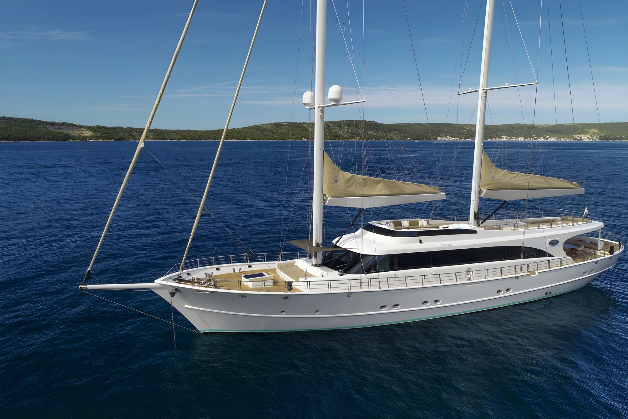 luxury white sailing yacht with two masts anchored in calm blue Mediterranean waters